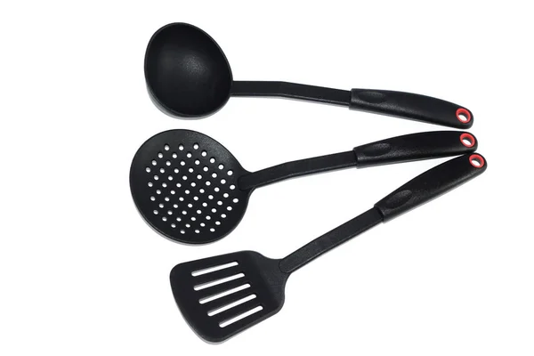 Ladle, spatula and skimmer from food plastic in black on a white background, isolate, kitchen utensils Stock Photo