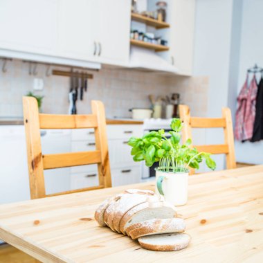 taze fesleğen, dilimlenmiş ekmek o mutfak masası