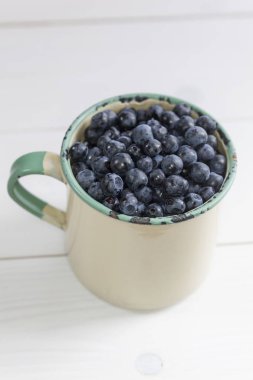 bir kupa arka plan üzerinde ham yaban mersini