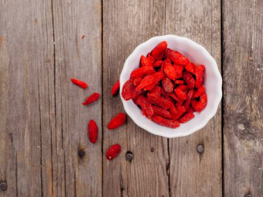 Goji meyveleri ahşap masa üzerinde bir kasede 