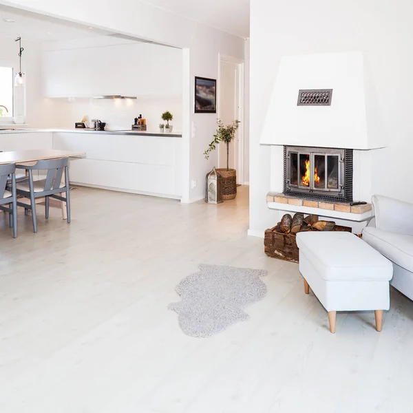 foreground fancy living room with lit fire in fireplace in the background