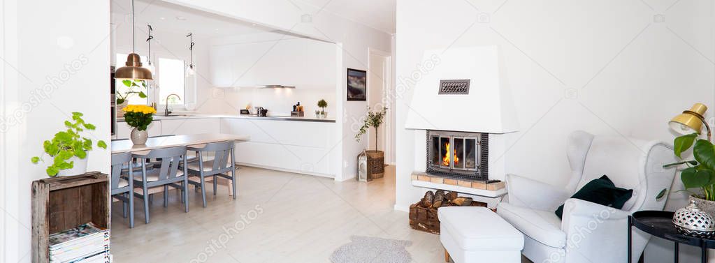 foreground fancy living room with lit fire in fireplace in the background