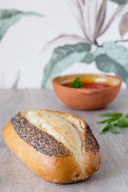 Ekmek, çiçek deseni duvar kağıdı masa önünde bir kase domates çorbası somun