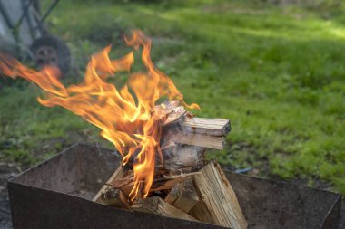Alev içinde mangal barbekü yemek hazırlığı sırasında yanan ahşap.