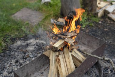 Alev içinde mangal barbekü yemek hazırlığı sırasında yanan ahşap.
