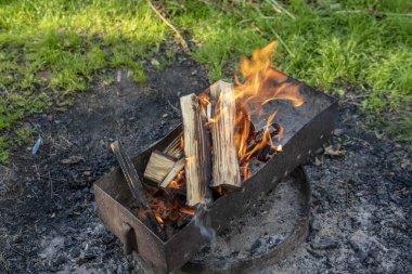 Alev içinde mangal barbekü yemek hazırlığı sırasında yanan ahşap.