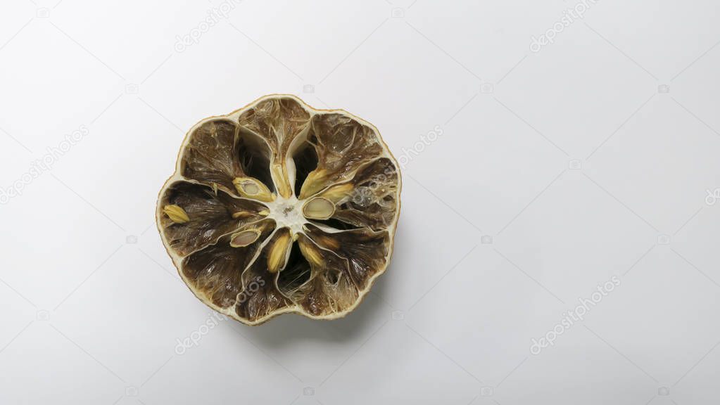 On the white table, the inside of the lemon is rotten and dried
