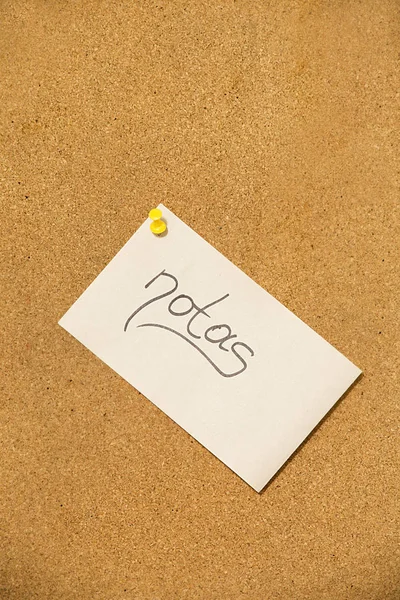 notes on the cork board- adhesive note with yellow pin on cork board