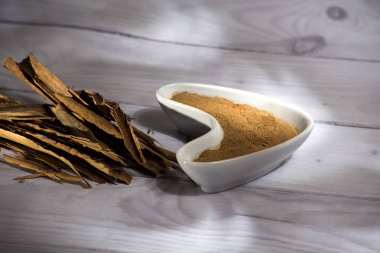 Beyaz ahşap arka plan-Cinnamomum verum izole toz tarçın beyaz kase