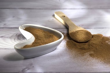 Beyaz ahşap arka plan-Cinnamomum verum izole bir tahta kaşık toz tarçın