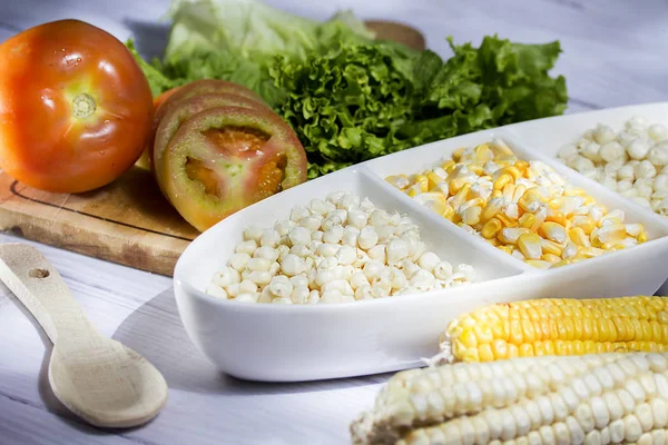 Beyaz ahşap arka planda - zengin salata tarafından - zea mays eşliğinde güzel beyaz kase mısır koçanı ve sarı mısır taneleri