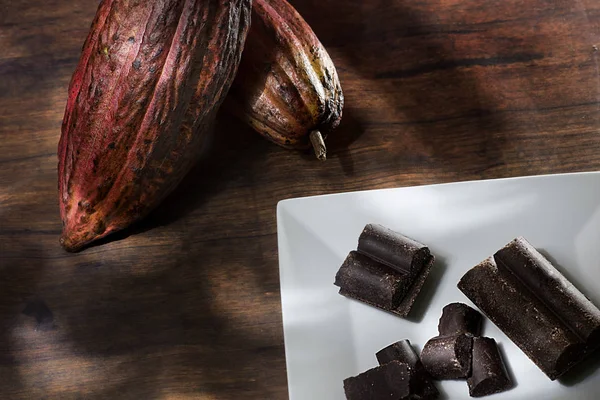 Çikolata ve kakao tozu ahşap arka plan üzerinde izole Theobroma kakao-kakao bakla.