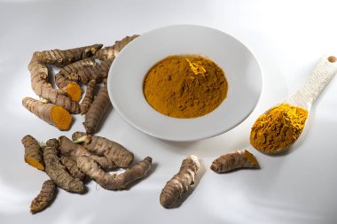 Longa zerdeçal ham organik portakal kök ve tıbbi bakım beyaz arka plan-kavramı üzerinde seramik kase toz.