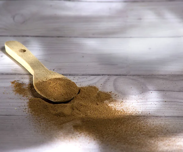 Beyaz ahşap arka plan-Cinnamomum verum izole bir tahta kaşık toz tarçın