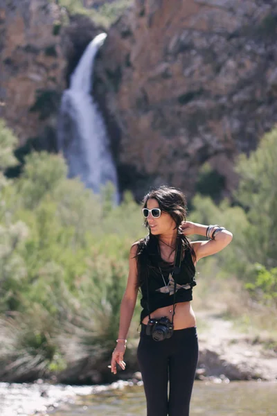 Güzel genç kadın dağ ve bir şelale