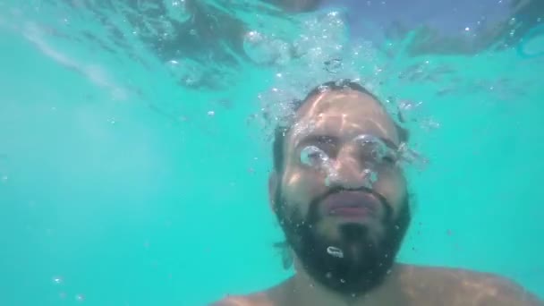 多くの気泡と水中 プールで遊ぶ若い男の美しい写真 — ストック動画