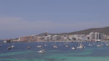 San Antonio Bay Ibiza Plajı, havadan görünümü, Ibiza, plajlar, uçan güvercinler ve geçen otomobil şehrin panoramik görünümü