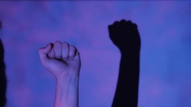 Adam renkli arka plan üzerinde kaldırdı yumruk ile