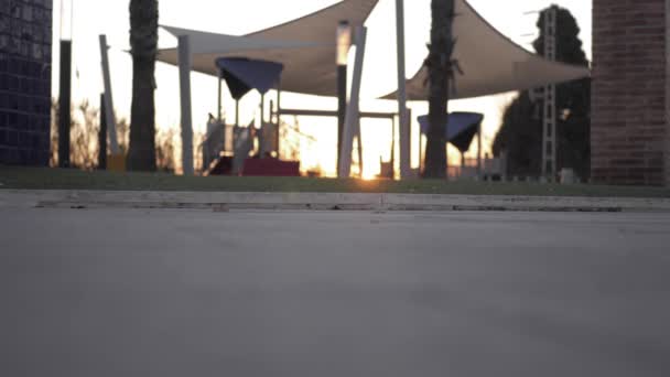 小さな女の子が日没時遊び場で遊んで — ストック動画