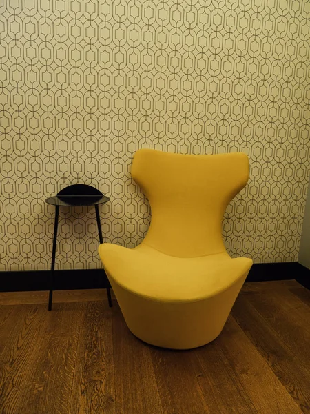 Siyah kahve masasının yanındaki sarı tasarım kanepe