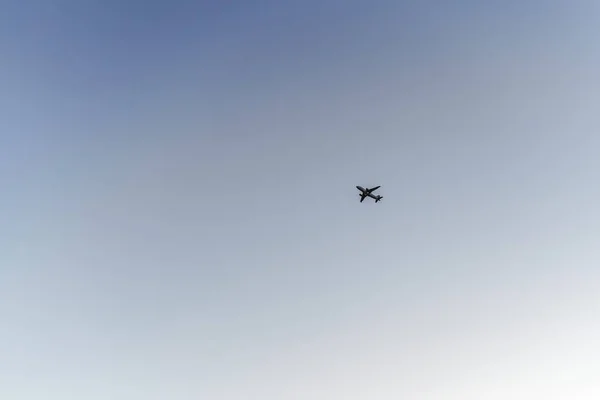 Полет самолета в ясном летнем небе, вид с земли — стоковое фото