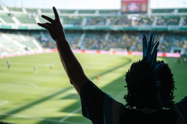 Arkadaşça bir futbol maçı, Arjantin 6 Ekvador 1 'e karşı, futbol taraftarı, ibikli saç stili, tribünden maç izliyor.