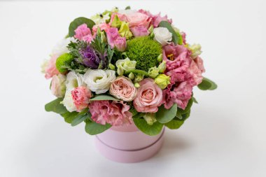 Hafif bir arka plan üzerinde bir küçük şapka kutusunda parlak çiçek buketi