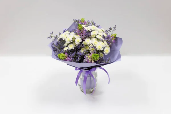 Bouquet (white chrysontemus) in paper packaging (purple)