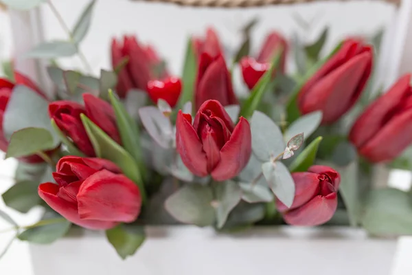 Stylish Arrangement Fresh Flowers Red Tulips Green Eucalyptus Leaves Wooden — Stock Photo, Image