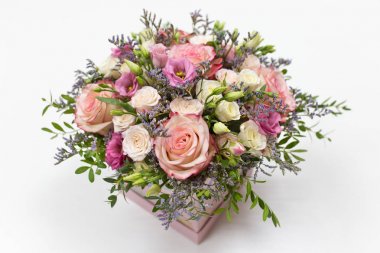 açık bir arka plan üzerinde kare karton kutu (birincil renk - pembe) gül ve canlı süslemeleri hassas çiçek düzenleme