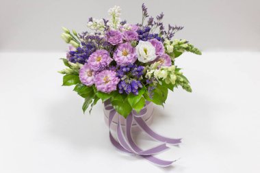 Gül, Eustoma, Veronica, Snapdragon ve Leylak (beyaz, leylak, yeşil mavi, kireç, mor) hafif bir arka plan üzerinde küçük bir hediye karton kutu zarif buket