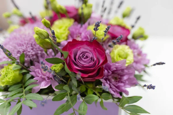 Perfect flower arrangement (Rose, Chrysanthemum, Eustoma, Lavender) in red and lilac colors on a light background