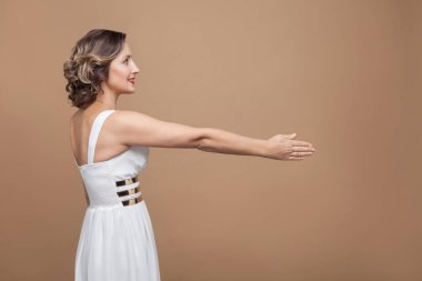hafif kahverengi zemin üzerine beyaz elbise gösteren el sıkışma kadında yan görünüm. Duygu ve duygu kavramı 