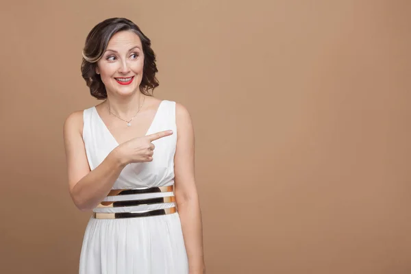 Feliz Sorrindo Mulher Apontando Dedo Para Direita Fundo Marrom Claro — Fotografia de Stock