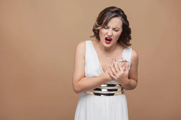 Frau Weißem Kleid Berühren Brust Während Herzschmerz Auf Hellbraunem Hintergrund — Stockfoto