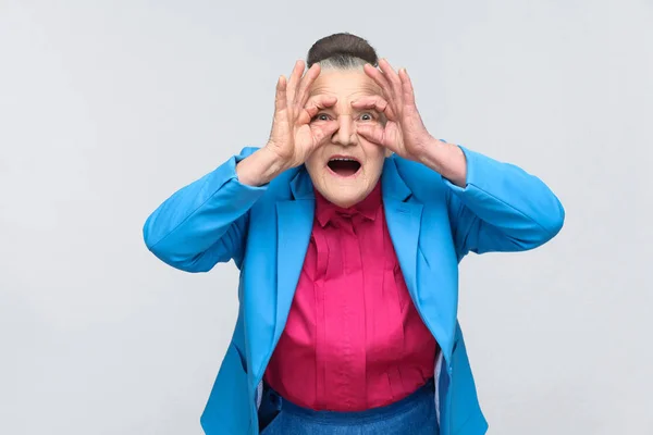 青いスーツとカメラ 感情と感情の概念を見てショックを受けた顔でピンクのシャツで高齢の祖母 — ストック写真
