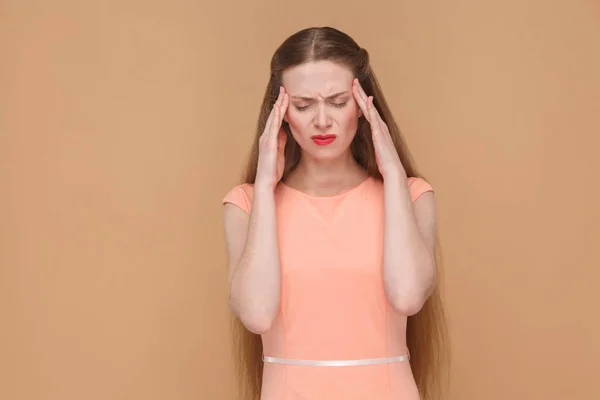 化粧と茶色の背景 片頭痛概念で頭痛しながら指で頭を触れるピンクのドレスには長い髪の美しい女性 — ストック写真