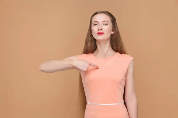 骄傲的女人在粉红色的礼服指向自己的手指 表达情感和情感概念 — 图库照片