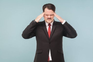 bıyıklı siyah takım elbise ve baş parmak tarafından açık mavi renkli, migren kavramı baş ağrısı yaparken dokunmadan kırmızı kravat giyen işadamı    