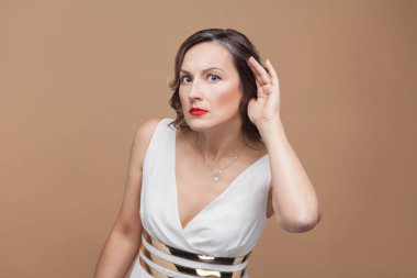 Dedikodu orta yaşlı kadın kahverengi zemin, genel kavram-in kulak yakınındaki beyaz elbise holding elinde seni duyamıyorum 