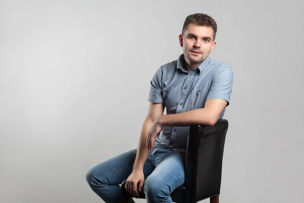 Joven Hombre Adulto Sentado Silla Posando Sobre Fondo Gris — Foto de Stock