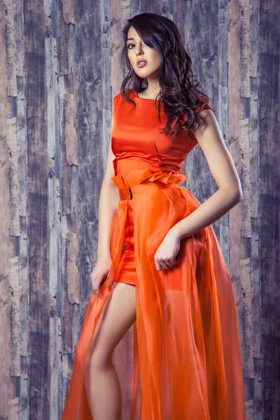 Mujer Morena Joven Elegante Vestido Seda Naranja Posando Sobre Fondo — Foto de Stock