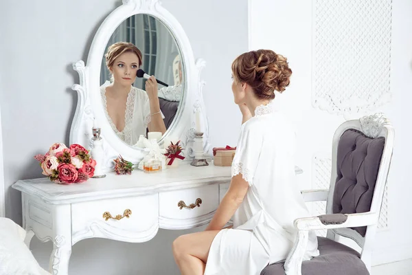 Genç mutlu kadın aynanın önünde oturan ve düğün için hazırlanıyor