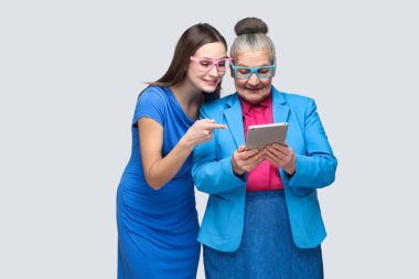 Mavi elbise işaret parmağı tablet adlı genç kızı görüntülemek elinde yaşlı kadının, torun ve Büyükanne arasında aile ilişkileri kavramı 