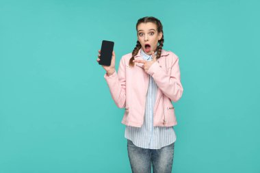 Hippi tarzı smartphone ekranında el ile işaret eden helezon saç modeli ile şok komik kadın yeşil arka yüzünde şaşırttı