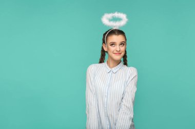 Çizgili mavi gömlek ve helezon saç modeli ile halo gülümseme ile yukarıya bakıp yeşil arka yüzünde rüya kafasına mutlu komik kadın