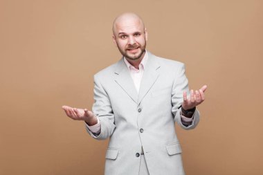 kameraya yükseltilmiş silahlarla seyir durup ve kahverengi arka plan üzerinde sormak klasik hafif gri takım işadamı yakışıklı karışık orta yaşlı sakallı