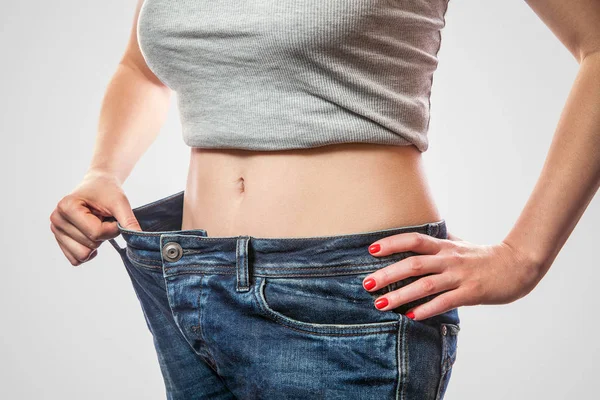 Close Slim Waist Young Woman Big Jeans Gray Top Showing — Stock Photo, Image