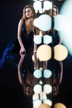 muhteşem parlak makyaj profesyonel aydınlatma ayna yakınındaki masada eğilerek koyu mavi parlak elbiseli kadınla 