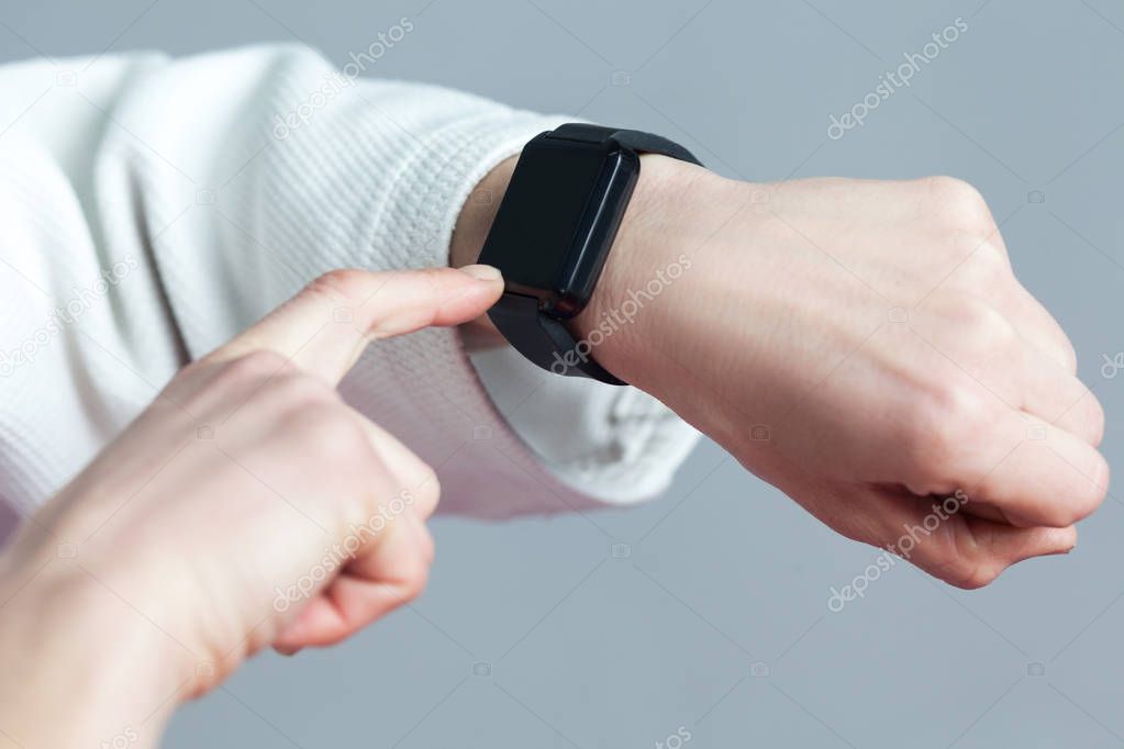 Female finger touching on screen of smartwatch on hand for checking burning calories, sport and healthcare concept